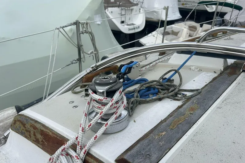 Slide: The Image of 1985 Catalina 36 sailboat deck with winch, ropes, and railing in a marina setting. - 17