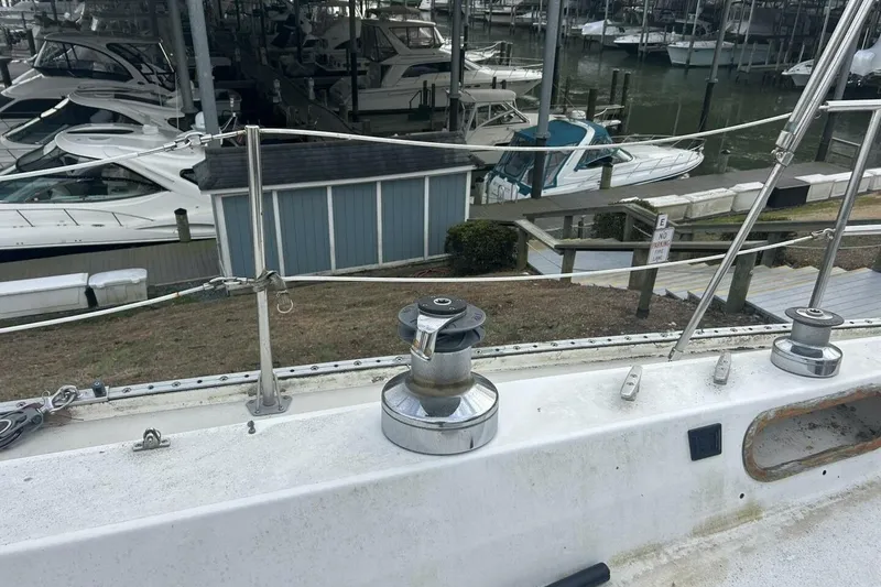 Slide: The Image of 1985 Catalina 36 sailboat deck with winches, docked at a marina with other boats. - 18