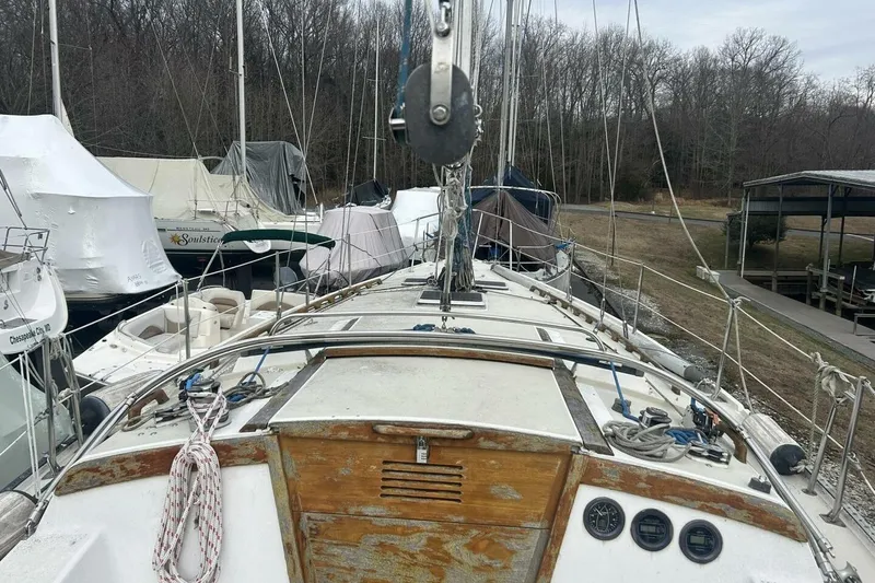Slide: The Image of 1985 Catalina 36 sailboat docked, showing deck and rigging, surrounded by other boats. - 19