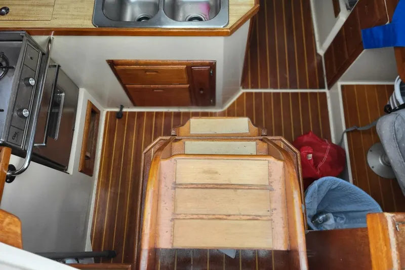 Slide: The Image of Interior of 1985 Catalina 36 sailboat with wooden flooring and compact kitchen area. - 21