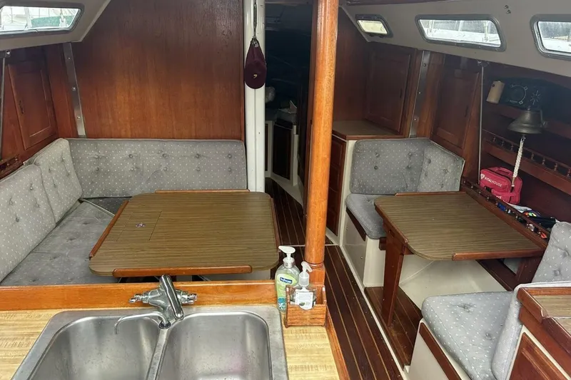 Slide: The Image of Interior of a 1985 Catalina 36 sailboat with wooden furnishings and seating area. - 23
