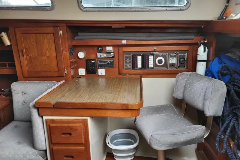 Slide: The Image of 1985 Catalina 36 yacht interior with navigation station, wooden cabinetry, and upholstered seating. - 27