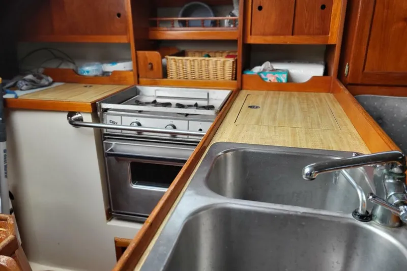 Slide: The Image of Galley kitchen in 1985 Catalina 36 sailboat with stove, sink, and wooden cabinetry. - 32
