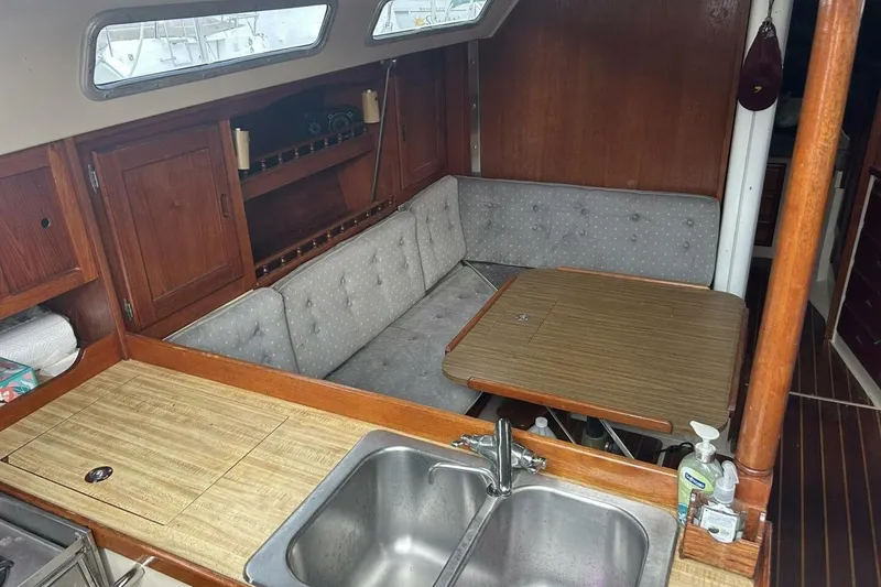 Slide: The Image of Interior of a 1985 Catalina 36 sailboat with a cozy dining area and kitchenette. - 37