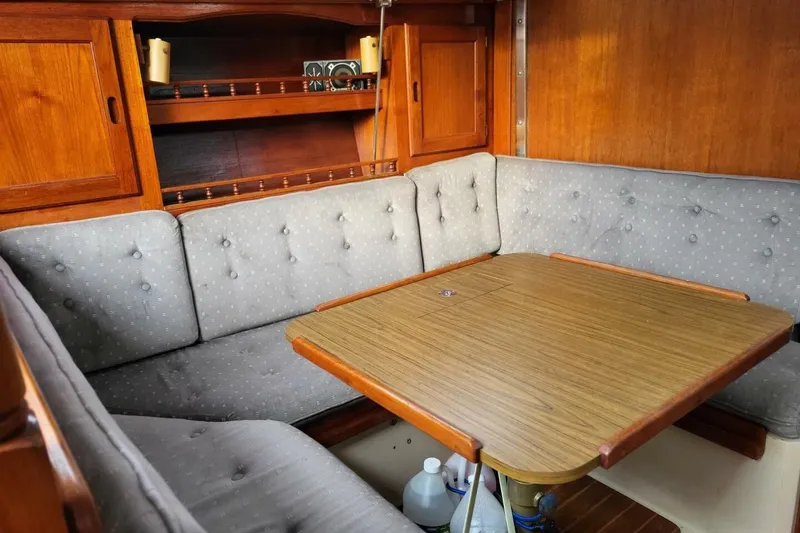 Slide: The Image of Cozy interior of 1985 Catalina 36 sailboat with wooden table and cushioned seating. - 39