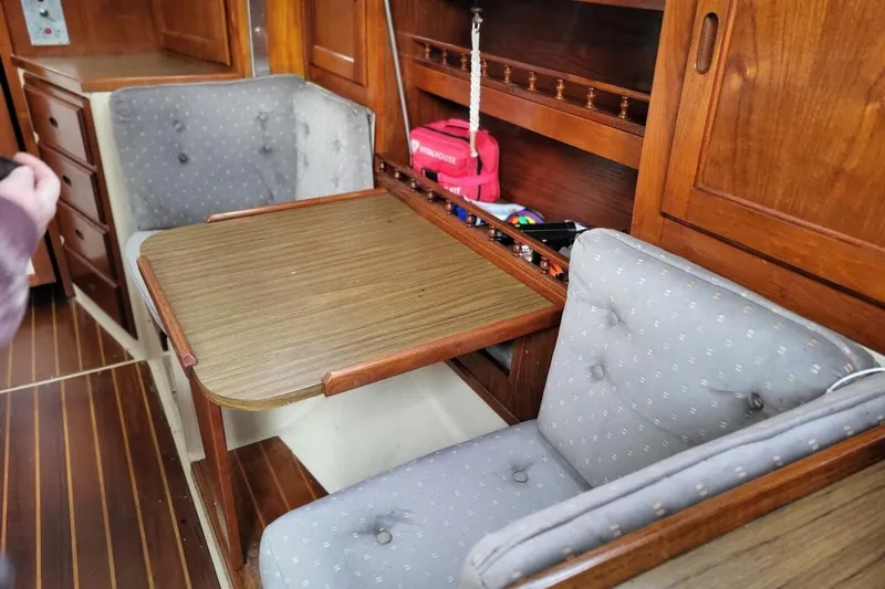 Slide: The Image of Interior of a 1985 Catalina 36 sailboat with wooden table and cushioned seating. - 40