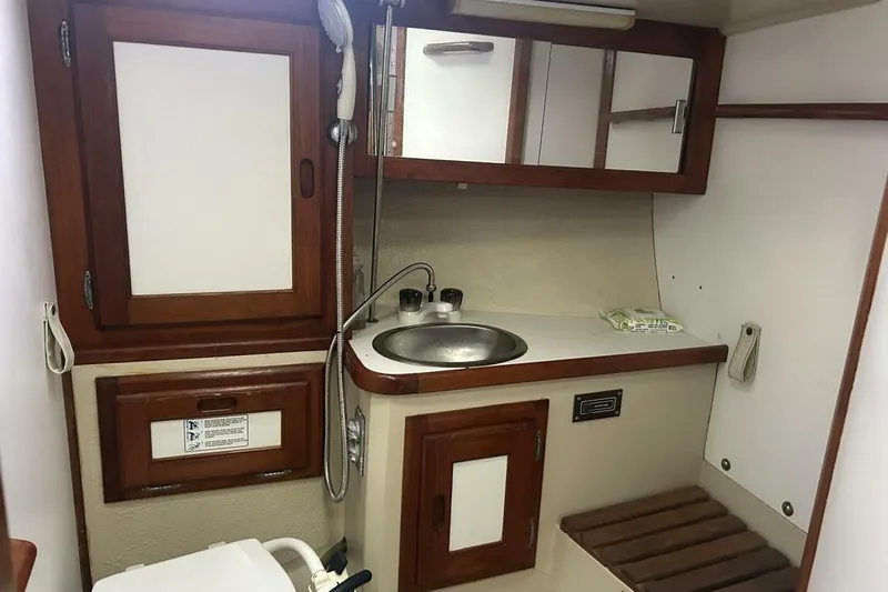 Slide: The Image of Interior of 1985 Catalina 36 sailboat bathroom with sink, mirror, and wooden accents. - 45