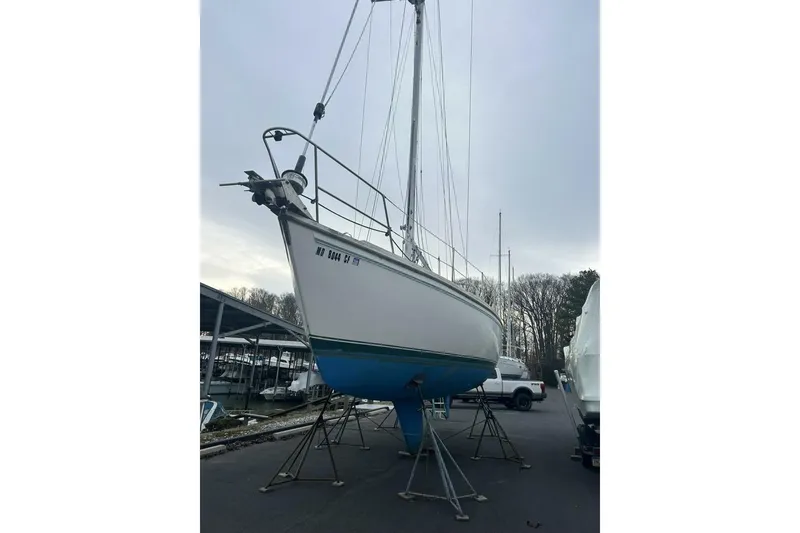 Slide: The Image of 1985 Catalina 36 sailboat on stands, marina background, overcast sky. - 5