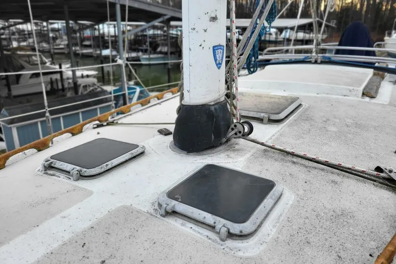 Slide: The Image of 1985 Catalina 36 sailboat deck with hatches and mast, docked in a marina. - 55