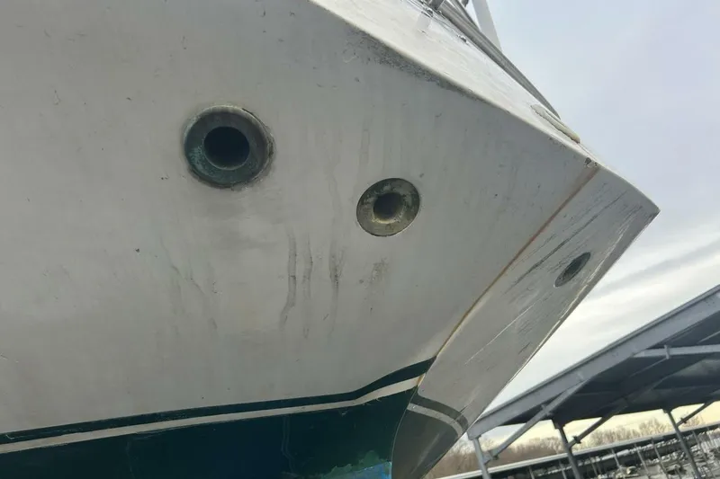 Slide: The Image of 1985 Catalina 36 boat hull with visible drain holes and weathered surface. - 59