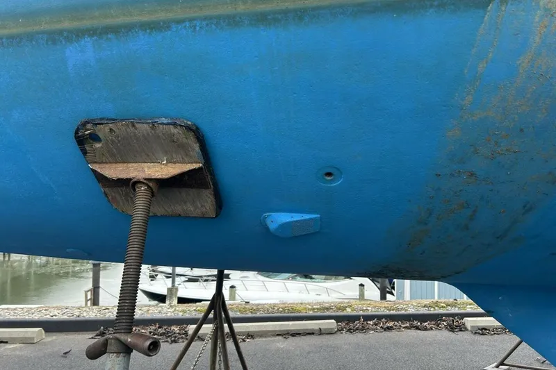 Slide: The Image of 1985 Catalina 36 sailboat hull in dry dock, supported by a metal stand. - 60