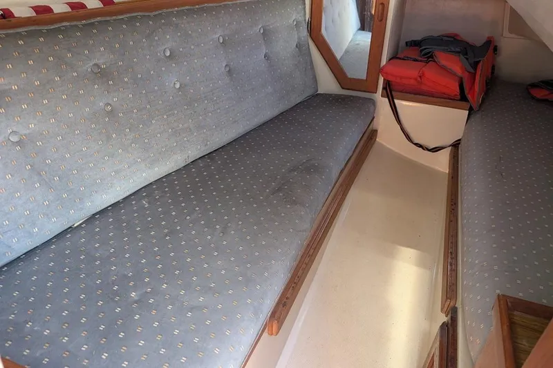 Slide: The Image of Interior cabin of a 1985 Catalina 36 sailboat with cushioned seating and life jackets. - 69