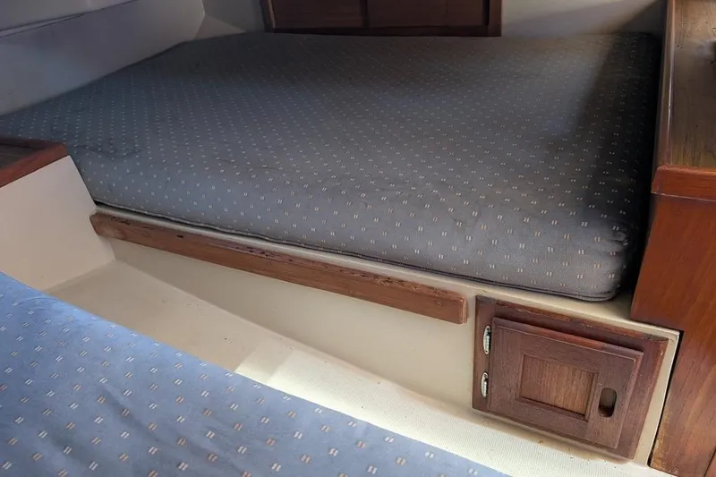 Slide: The Image of Interior cabin of a 1985 Catalina 36 sailboat with cushioned berth and wooden storage. - 71