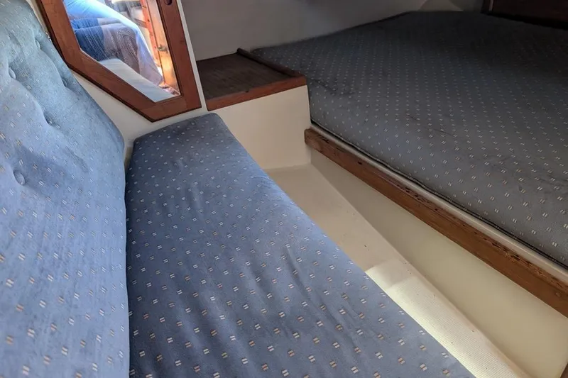 Slide: The Image of Interior cabin of a 1985 Catalina 36 sailboat with blue upholstered seating. - 75