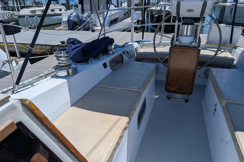 Slide: The Image of 1985 Catalina 36 sailboat cockpit with seating, steering wheel, and marina background. - 78