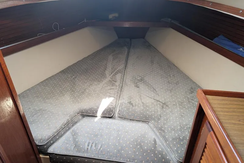 Slide: The Image of Interior cabin view of a 1985 Catalina 36 sailboat with cushioned sleeping area. - 83