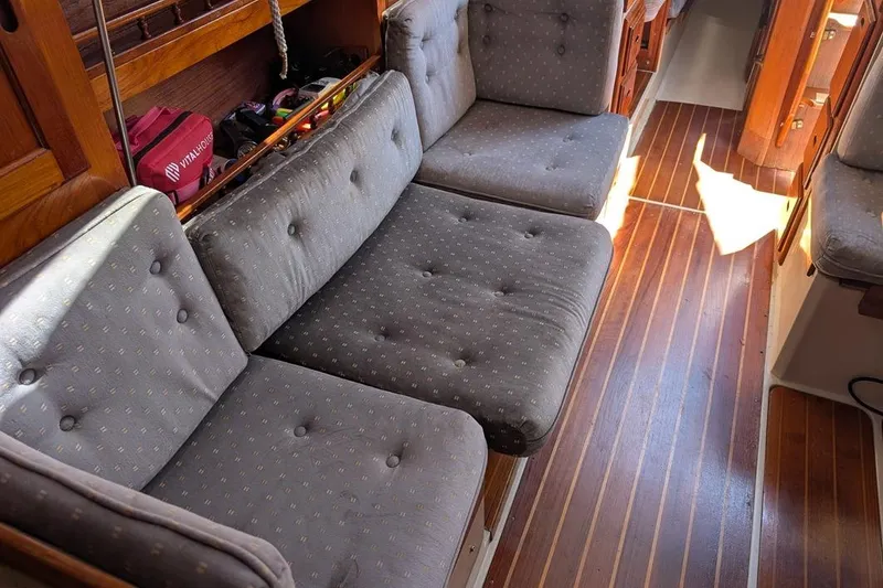 Slide: The Image of Interior of 1985 Catalina 36 sailboat with cushioned seating and wooden flooring. - 85