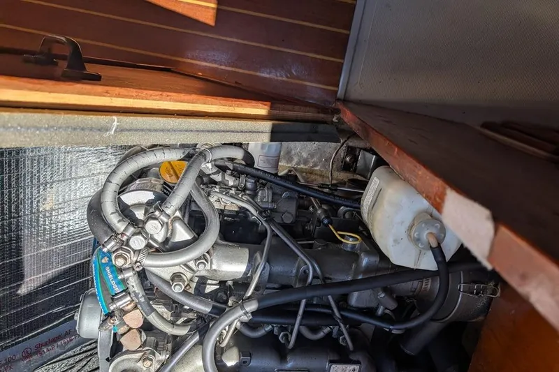 Slide: The Image of Engine compartment of a 1985 Catalina 36 sailboat, showcasing mechanical components and hoses. - 87