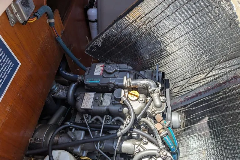 Slide: The Image of Engine compartment of a 1985 Catalina 36 sailboat, showcasing mechanical components and wiring. - 88