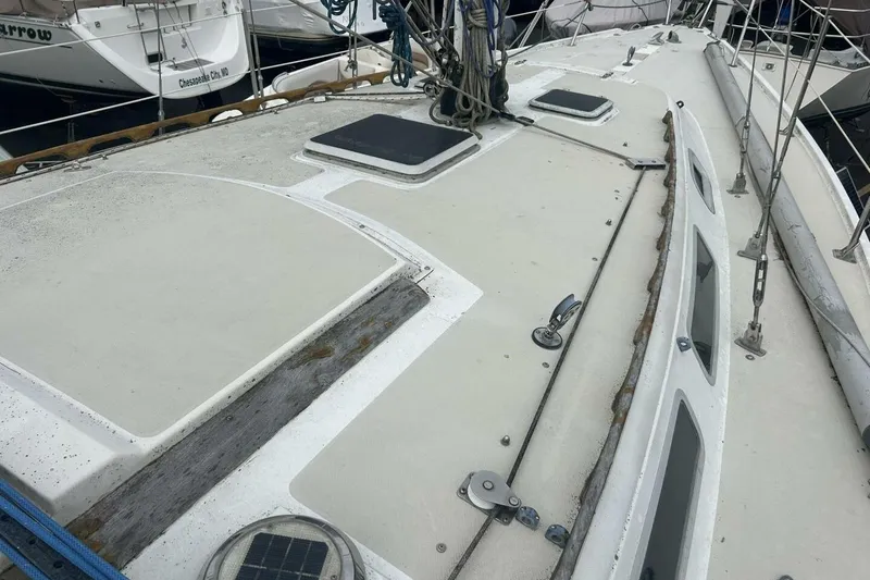 Slide: The Image of 1985 Catalina 36 sailboat deck with hatches and rigging in a marina setting. - 9