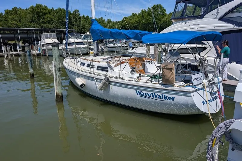 Slide: The Image of 1985 Catalina 36 sailboat "WaveWalker" docked at marina with blue canopy. - 93