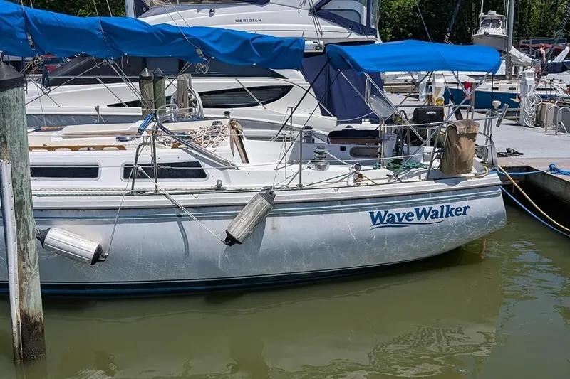 Slide: The Image of 1985 Catalina 36 sailboat "WaveWalker" docked at marina with blue canopy. - 96