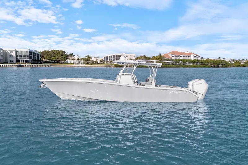 The Image of 2026 Yellowfin 32 Offshore boat on calm water, with coastal buildings in the background. - 0