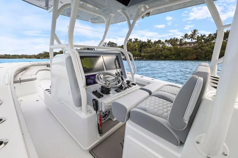 Slide: The Image of 2026 Yellowfin 32 Offshore boat interior with modern helm and seating on a sunny day. - 11
