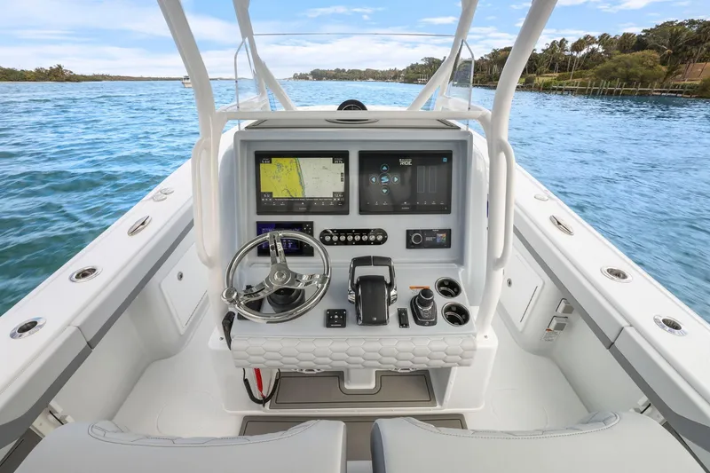 Slide: The Image of 2026 Yellowfin 32 Offshore boat cockpit with advanced navigation system on a serene waterway. - 13