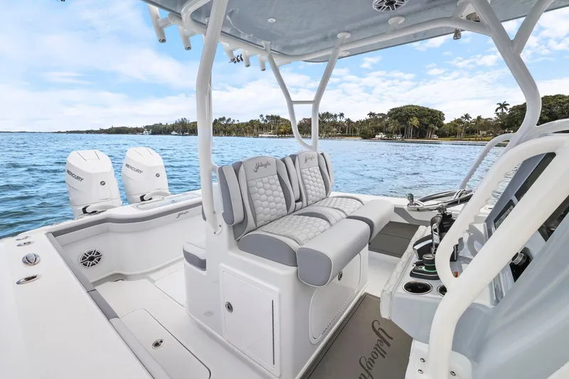 Slide: The Image of 2026 Yellowfin 32 Offshore boat interior with dual Mercury engines on a scenic waterway. - 17