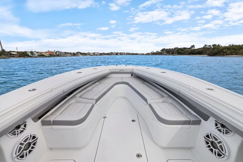 Slide: The Image of 2026 Yellowfin 32 Offshore boat interior with cushioned seating on calm water. - 23