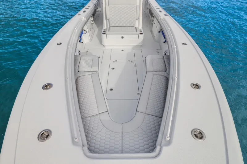 Slide: The Image of 2026 Yellowfin 32 Offshore boat deck with cushioned seating, floating on clear blue water. - 25