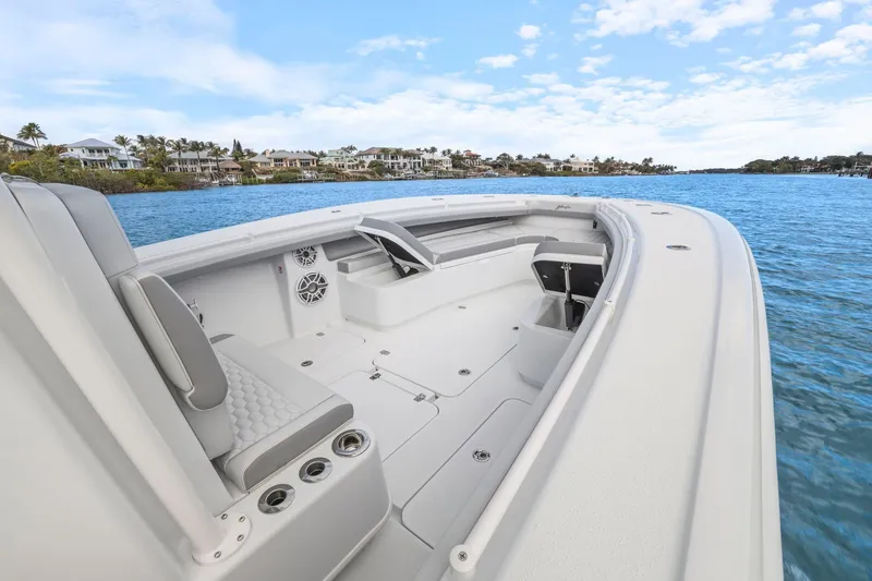 Slide: The Image of 2026 Yellowfin 32 Offshore boat interior with seating, on a scenic waterway. - 33