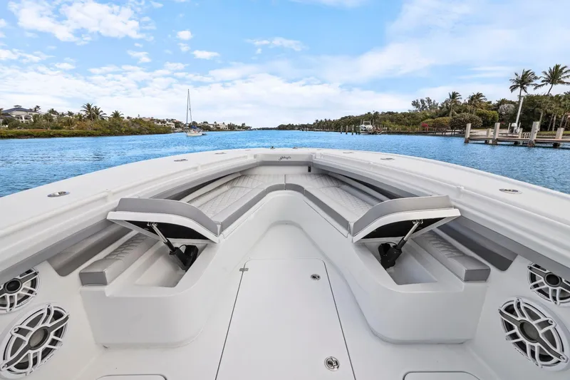Slide: The Image of 2026 Yellowfin 32 Offshore boat interior with seating, cruising on a scenic waterway. - 34