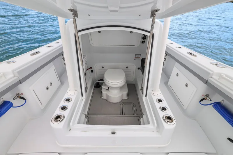 Slide: The Image of 2026 Yellowfin 32 Offshore boat interior with marine toilet, open sea view. - 41