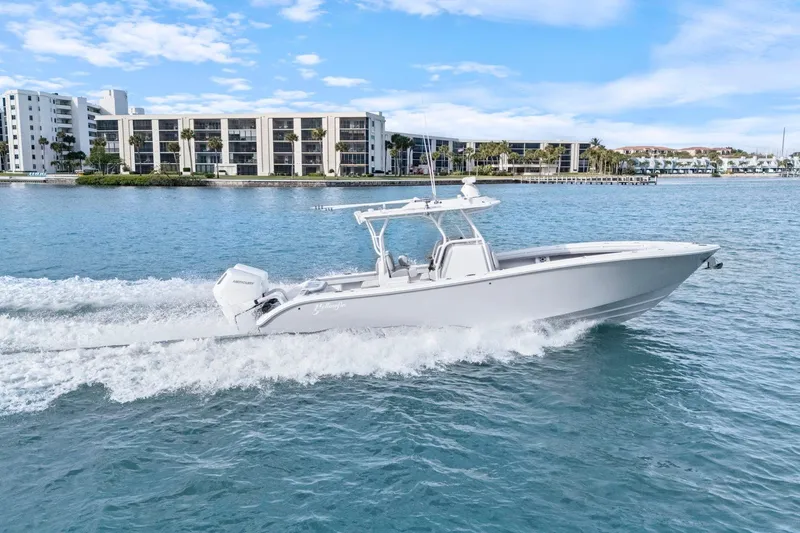 Slide: The Image of 2026 Yellowfin 32 Offshore boat cruising on blue water near modern buildings. - 47