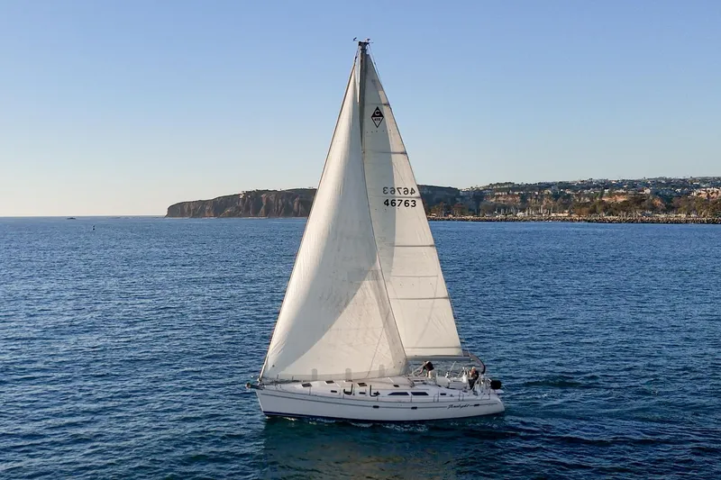 The Image of Sailboat Catalina 470 (1999) cruising on open sea with coastal backdrop. - 1