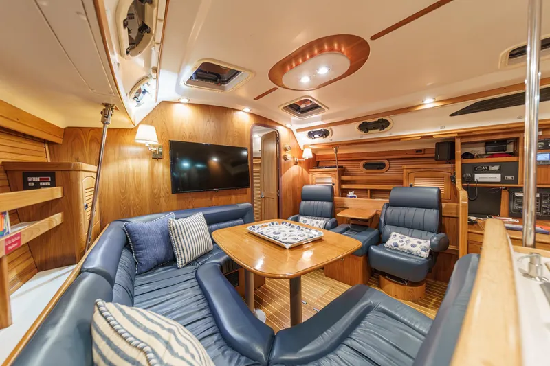 Slide: The Image of Luxurious interior of a 1999 Catalina 470 yacht with blue leather seating and wooden accents. - 28