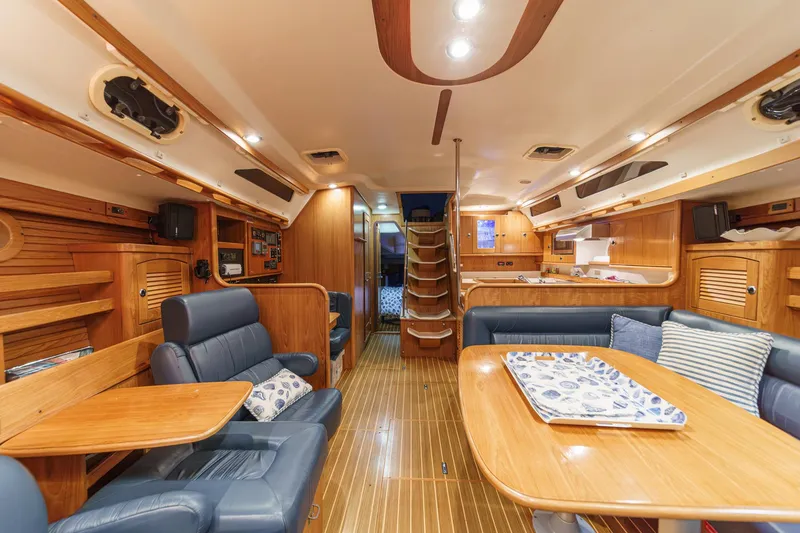 Slide: The Image of Luxurious 1999 Catalina 470 yacht interior with wooden furnishings and blue seating. - 31