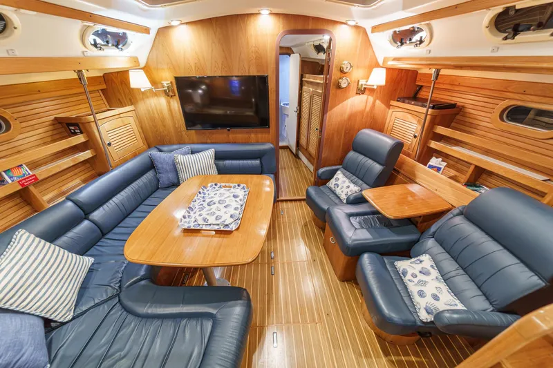 Slide: The Image of Luxurious interior of 1999 Catalina 470 yacht with plush seating and wooden finishes. - 32