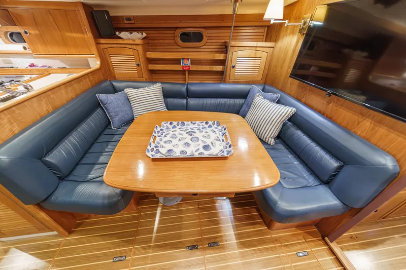 Slide: The Image of Luxurious interior of 1999 Catalina 470 yacht with blue leather seating and wooden accents. - 34