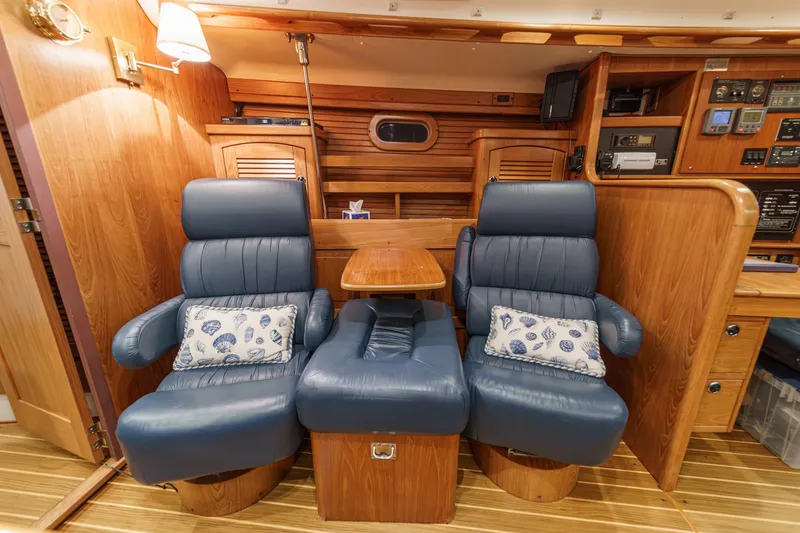 Slide: The Image of Luxurious interior of 1999 Catalina 470 yacht with blue leather chairs and wooden accents. - 35