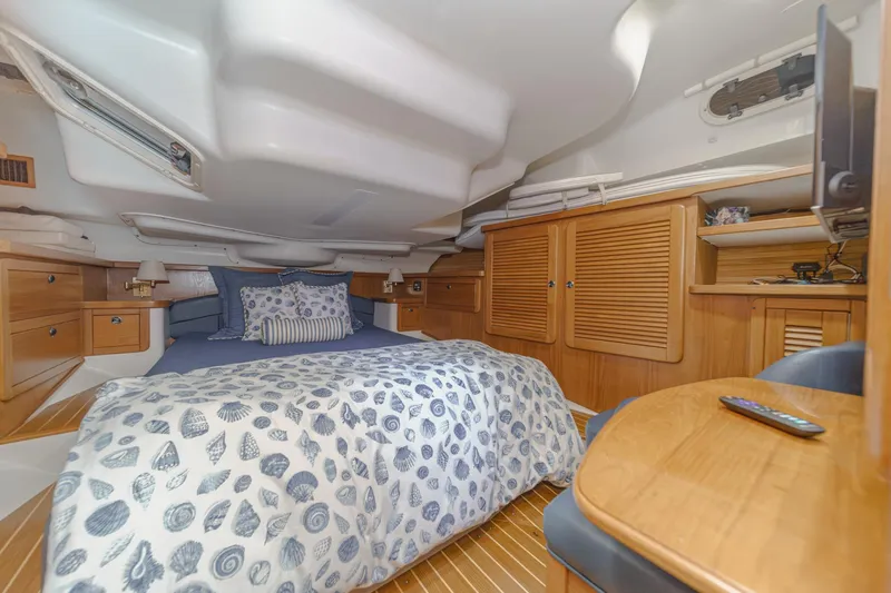 Slide: The Image of Cozy cabin interior of 1999 Catalina 470 sailboat with bed, wooden cabinets, and nautical decor. - 38