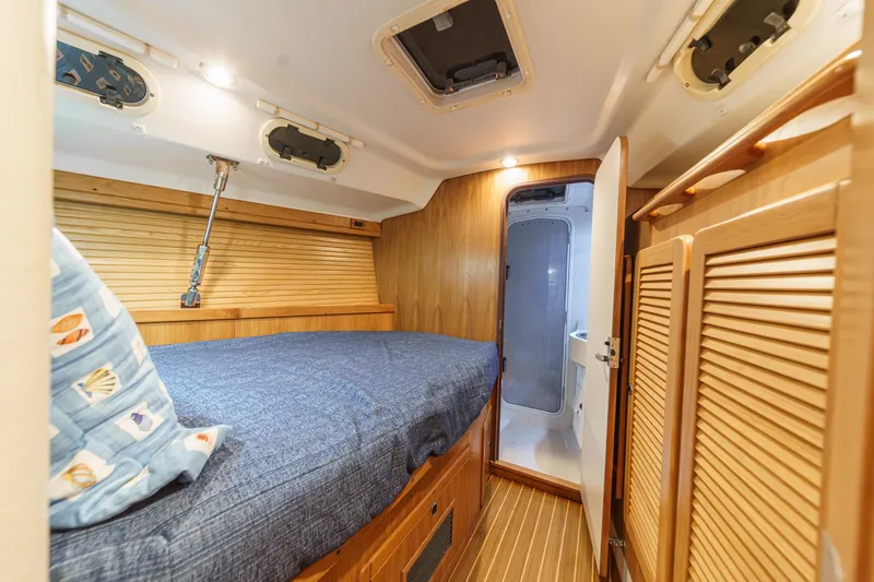 Slide: The Image of Cozy cabin interior of 1999 Catalina 470 sailboat with wooden finishes and blue bedding. - 43