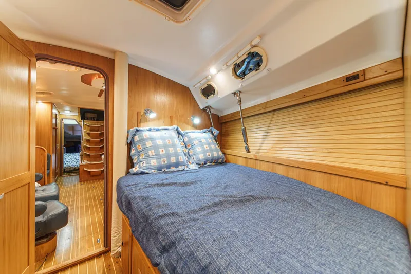 Slide: The Image of Cozy cabin interior of 1999 Catalina 470 sailboat with wooden finish and comfortable bedding. - 44