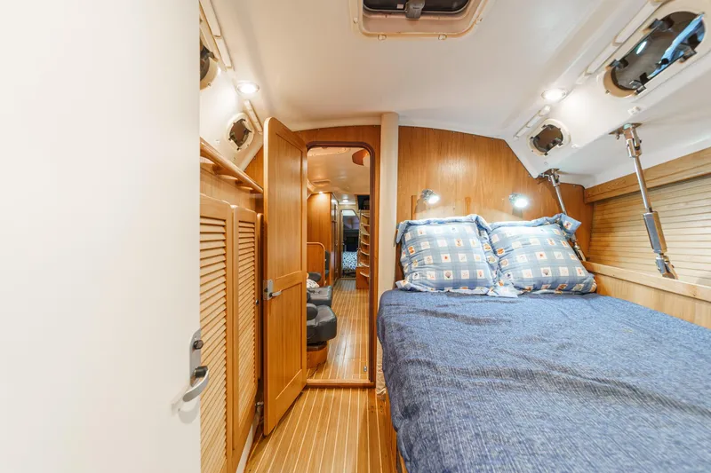 Slide: The Image of Cozy cabin interior of 1999 Catalina 470 yacht with wooden finishes and blue bedding. - 45