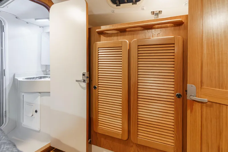 Slide: The Image of Interior of 1999 Catalina 470 yacht featuring wooden cabinets and a compact bathroom sink. - 46