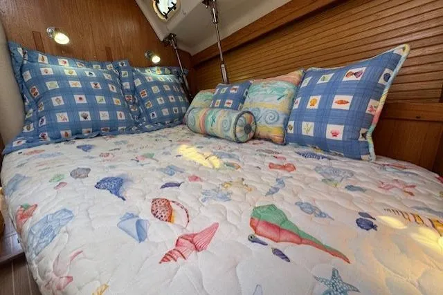 Slide: The Image of Cozy cabin bed in 1999 Catalina 470 sailboat with nautical-themed bedding and pillows. - 54