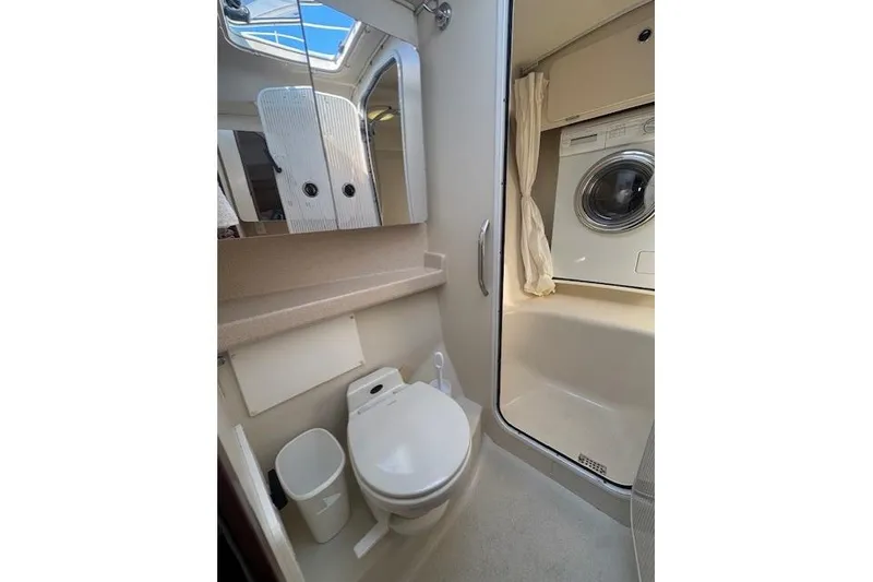 Slide: The Image of Bathroom and laundry area in a 1999 Catalina 470 yacht, featuring a toilet and washing machine. - 55