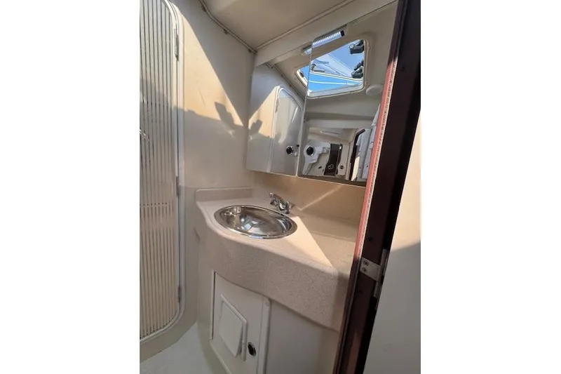Slide: The Image of 1999 Catalina 470 yacht bathroom with sink, mirror, and storage cabinet. - 56